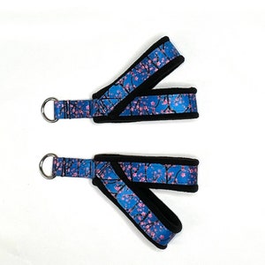 May include: Two blue and black straps with a pink floral pattern and metal rings. The straps are padded with black fleece.