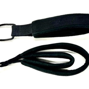 May include: A black padded leash with a metal loop at one end and a black padded handle at the other end.