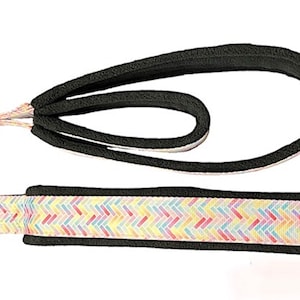 May include: A black and pastel-colored dog leash and handle set. The leash is black with a padded handle. The leash has a pastel chevron pattern. The set includes metal rings for attachment.