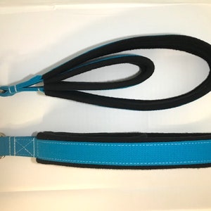 May include: Two blue and black dog leashes with metal rings. The leashes are made of a soft, padded material.