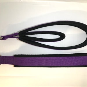 May include: Two purple straps with black trim and metal rings. The straps are made of a soft, padded material.