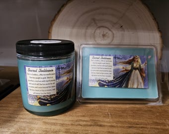 May include: A teal-colored candle in a glass jar with a black lid, and a teal wax melt in a clear plastic container. Both items have labels with the text "Sacred Goddesses" and an illustration of a woman in a flowing gown.