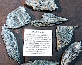 May include: A collection of black kyanite crystals. Black kyanite is a grounding and energizing stone that can help clear blocked energies in all chakras.  Clear blocked energies in all chakras. Grounding and energizing, great for energetic healing, clears imbalances. Can take one back to past lives and forward to probable futures. Increasing ones vibrational frequencies without taking one out of the body. Teaches one to experience interdimensional consciousness without losing one's connection to earth.