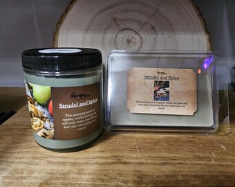 May include: A glass jar candle and a wax melt container with the text "Strudel and Spice." The candle has a black lid and a label with images of apples. The wax melt is in a clear plastic container.