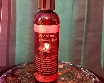 May include: A brown glass bottle with a spray nozzle and a label that reads "Palo Santo Cleansing Spray". The label also includes information about the traditional uses of Palo Santo wood, such as for clearing negative energy and promoting relaxation.