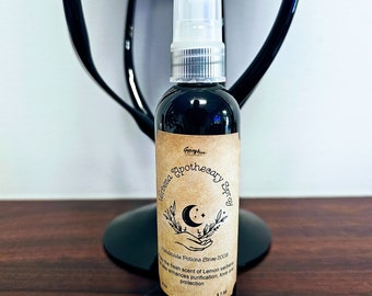 May include: A dark glass bottle of Verbena Apothecary Spray with a white spray nozzle. The label features a crescent moon and stars design. The text on the label reads "Handmade Potions Since 2008" and describes the scent as lemon verbena.