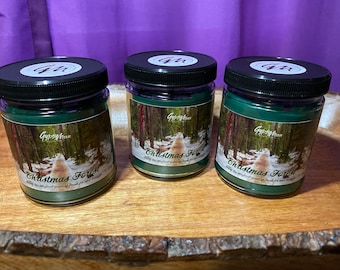 May include: Three green glass candle jars with black lids and labels that say "Gypsy Moon" and "Christmas Forest" Enjoy the magical scent of fresh fir and cedar.