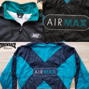 May include: Black and teal Nike Air Max windbreaker jacket with a zipper closure and a large Air Max logo on the back. The jacket has a contrasting teal collar and a Nike logo on the left chest.