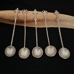 May include: Set of six silver teaspoons with ornate handles and decorative bowls. Each spoon features a star and crescent moon design.