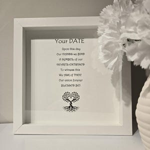 May include: A framed print with the text "Your DATE" and a poem about a union. The print features a tree with intertwined hearts at the bottom. The frame is white, and the background is a light color.