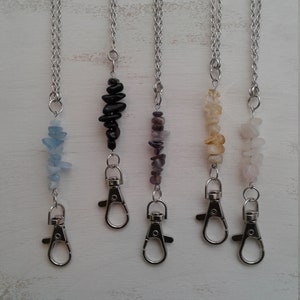 May include: Five silver chain necklaces with different coloured gemstone pendants and silver lobster claw clasps. The gemstones are aquamarine, black onyx, amethyst, citrine, and rose quartz.