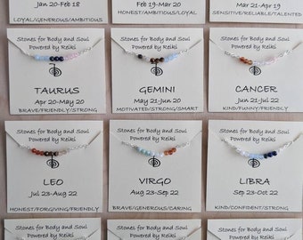 May include: Twelve cards with different zodiac signs, each with a different color gemstone necklace. The cards are white with black text and the text "Stones for Body and Soul Powered by Reiki". The cards are arranged in a grid of four rows and three columns. The zodiac signs are Aquarius, Pisces, Aries, Taurus, Gemini, Cancer, Leo, Virgo, Libra, Scorpio, Sagittarius, and Capricorn.