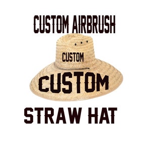 May include: A natural straw hat with a wide brim, featuring the text "CUSTOM AIRBRUSH" above and "CUSTOM" on the hat's crown and brim, and "STRAW HAT" below. The hat is a light tan colour.