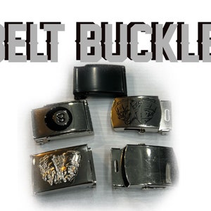May include: Five belt buckles, including one black buckle and four silver buckles with different designs. The silver buckles feature a pool ball with the number eight, a skull, a butterfly, and a plain design.