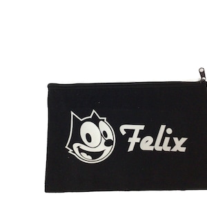 May include: Black canvas zippered pouch with a white Felix the Cat cartoon character and the word "Felix" in white.