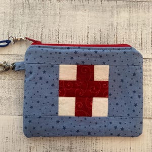 May include: A white ceramic mug with a black handle and the text "But First, Coffee" in a bold, black font. The mug is sitting on a wooden surface. The mug is 4 inches tall.