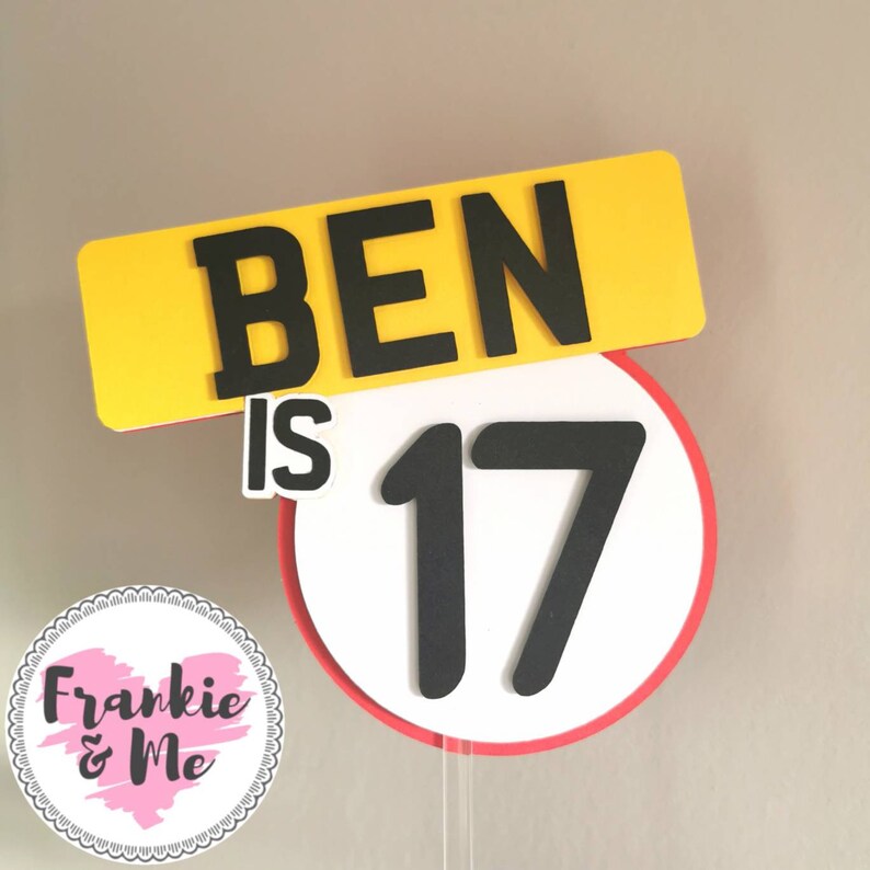 Puede incluir: Topper de pastel amarillo y rojo con el texto "BEN IS 17" en negro. El n&uacute;mero 17 est&aacute; en un c&iacute;rculo blanco con borde rojo.