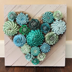 Décoration murale en bois représentant un cœur de pomme de pin et des succulentes, peinte à la main : composition florale.