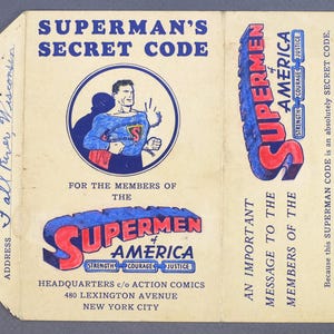 May include: A vintage Superman Secret Code membership card with a red, white, and blue Superman logo and a drawing of Superman in a blue suit with a red cape. The card has the text "SUPERMAN'S SECRET CODE" and "FOR THE MEMBERS OF THE SUPERMEN OF AMERICA" printed on it.