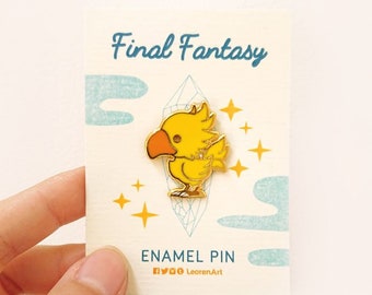 Pode incluir: Um broche de esmalte dourado com uma criatura amarela semelhante a um pintinho com bico e asas laranja. O broche está em um cartão com o texto "Final Fantasy" e "Enamel Pin" com ícones de mídia social e o texto "LeorenArt".