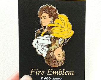 Peut inclure: Épinglette en émail doré représentant un personnage de la série de jeux vidéo Fire Emblem. L'épingle est sur une carte noire avec le texte "Fire Emblem" et "LeorenArt".
