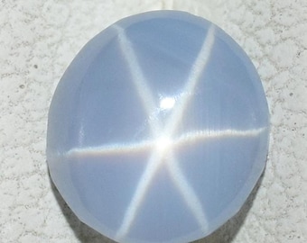 Könnte beinhalten: Ein runder, hellblauer Stern-Saphir-Edelstein mit einem sechszackigen Stern in der Mitte.