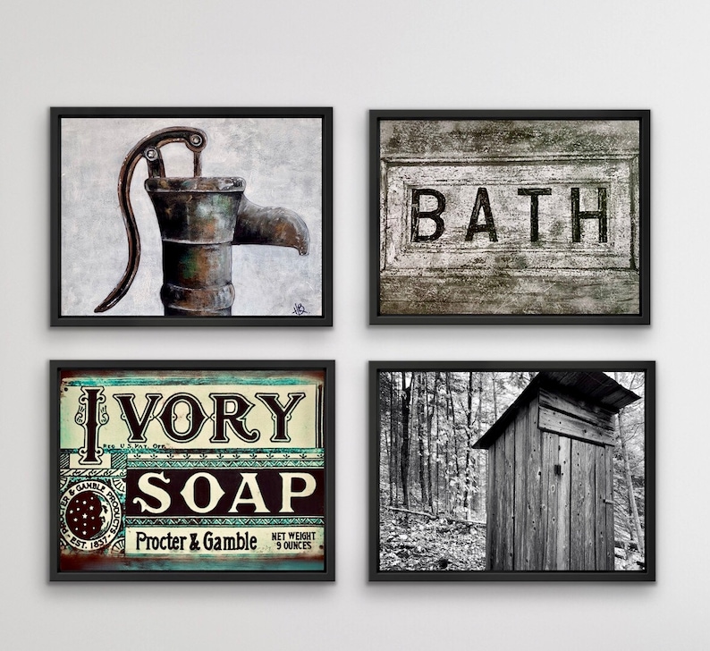 May include: Four framed wall art pieces. One features a rustic water pump, another reads "BATH" in bold letters. A third displays an "IVORY SOAP" sign, and the last is a black and white photo of a wooden outhouse.