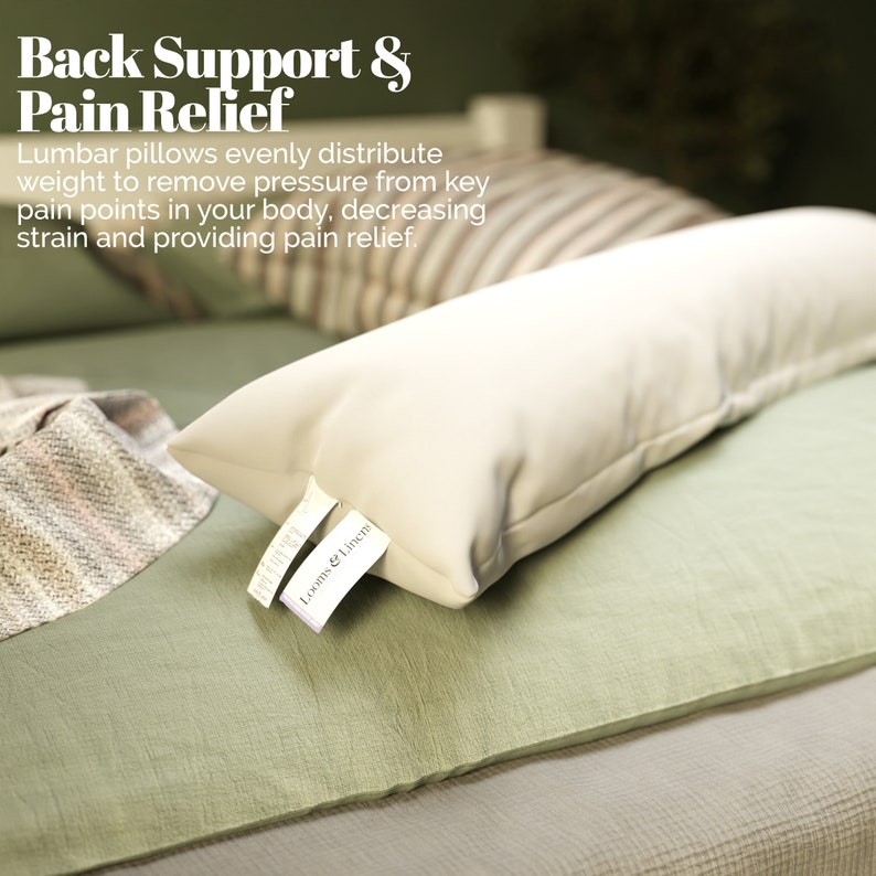 May include: A white lumbar pillow with a white tag that says "Looms & Linens" on a green bedspread. The pillow is designed to provide back support and pain relief.