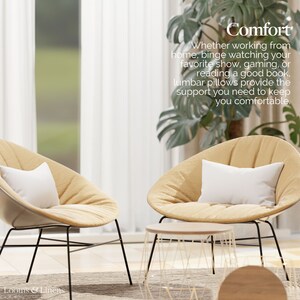 May include: Two beige chairs with white pillows and black metal frames. A small round wooden table sits between the chairs. The chairs are in a room with a large window and a green plant. The text "Comfort" is written in white on a black background above the chairs. The text below the word "Comfort" reads "Whether working from home, binge watching your favorite show, gaming, or reading a good book, lumbar pillows provide the support you need to keep you comfortable."