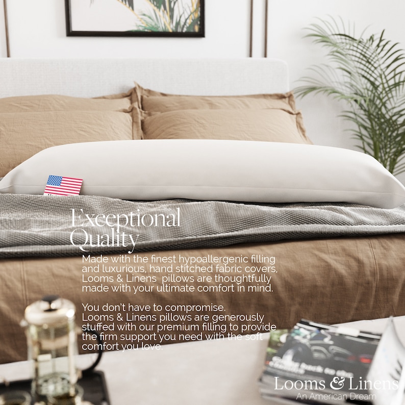 May include: A white body pillow with a gray and white patterned bedspread. The text "Exceptional Quality" is displayed on the bedspread. The text "Made with the finest hypoallergenic filling and luxurious, hand stitched fabric covers, Looms & Linens pillows are thoughtfully made with your ultimate comfort in mind. You don't have to compromise. Looms & Linens pillows are generously stuffed with our premium filling to provide the firm support you need with the soft comfort you love." is also displayed on the bedspread. The text "Looms & Linens An American Dream" is displayed on a book on a table in the foreground.