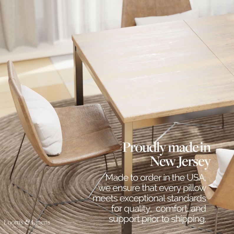 May include: A wooden dining table with two chairs. The table has a light wood finish and the chairs have brown leather seats. The text "Proudly made in New Jersey" is visible on the table. The text "Made to order in the USA, we ensure that every pillow meets exceptional standards for quality, comfort, and support prior to shipping." is also visible on the table.