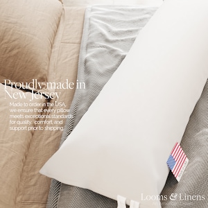 May include: A white pillow with a "Made in USA" label, resting on a gray and white striped fabric. The text "Proudly made in New Jersey" is visible in the background. The text "Made to order in the USA, we ensure that every pillow meets exceptional standards for quality, comfort, and support prior to shipping." is also visible in the background.
