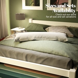 May include: A white bed frame with a green and grey bedding set. The bed has a white pillow and a striped pillow. The text "Sizes and Sets Availability" is displayed above the bed. The text "Check out our store for all size and set variations" is displayed below the bed.