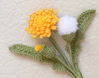 May include: A crocheted dandelion bouquet with yellow and white flowers and green leaves.