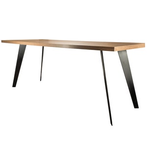 Op de afbeelding: Een lange, rechthoekige houten tafel met een lichtbruine afwerking en zwarte metalen poten. De poten zijn schuin en steken uit de tafelblad.