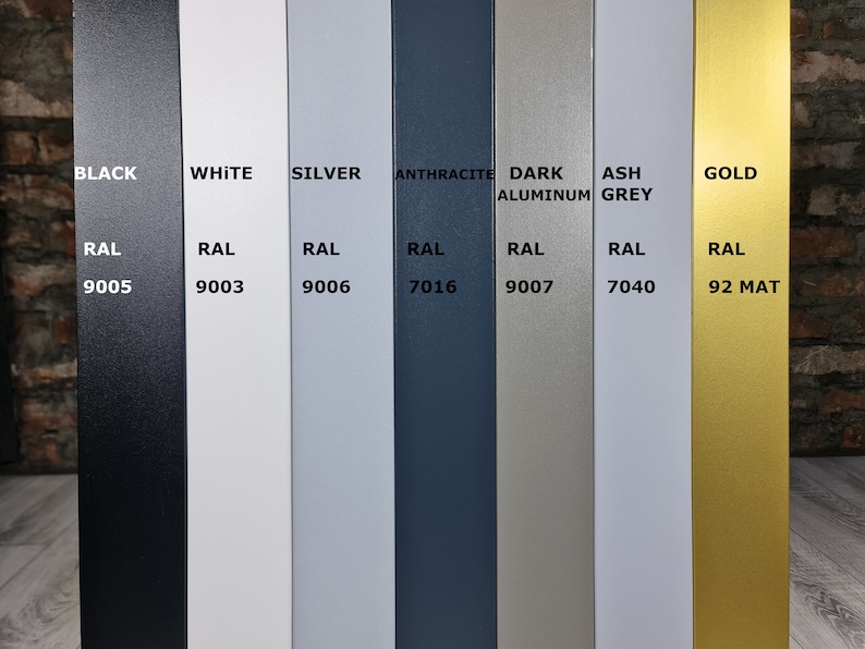 Op de afbeelding: Een kleurenkaart met acht verschillende verfkleuren met hun bijbehorende RAL-nummers. De kleuren zijn zwart, wit, zilver, antraciet, donker aluminium, asgrijs en goud.