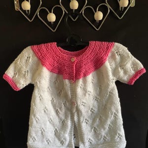 Toddlers yoke knitted dress in a pretty lace pattern white with pink border