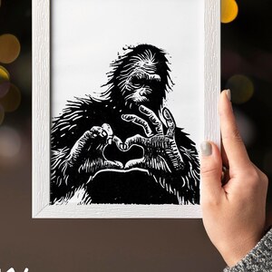 Può includere: Stampa a legno in bianco e nero di un Bigfoot che fa un cuore con le mani.