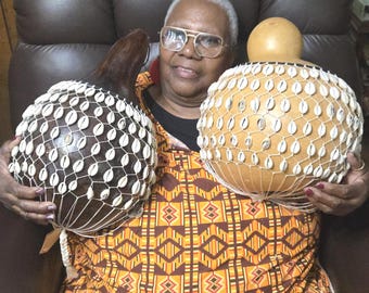 タカラガイの殻でできたひょうたんのシェケレ：白いビーズで飾られた