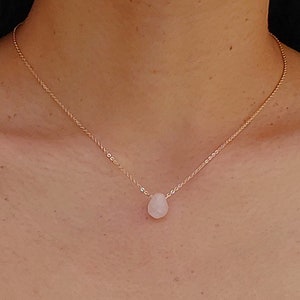 Peut inclure: Un collier délicat en chaîne dorée avec un pendentif en forme de larme de pierre précieuse rose clair.