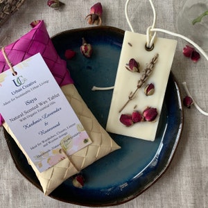 K&ouml;nnte beinhalten: Ein nat&uuml;rliches Wachstablett mit getrockneten Lavendel- und Rosenbl&uuml;ten, verpackt in einem geflochtenen Korb. Das Etikett lautet "iSayu Natural Scented Wax Tablet with Organic Essential Oils Kashmir Lavender & Rosewood Ideal for Wardrobes, Closets, Linens and Woolen storage Handmade - Natural - Biodegradable".