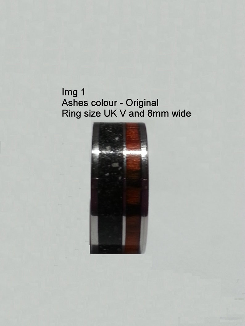 May include: A black and brown ring with a wood inlay. The ring is 8mm wide and size UK V.