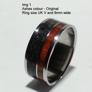 May include: A silver ring with a black and red inlay. The ring is 8mm wide and is a UK size V.