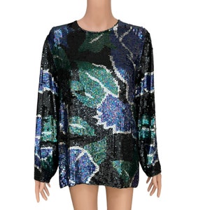 May include: A long-sleeved, black sequined top with a colorful abstract floral pattern in shades of blue, green, and white.