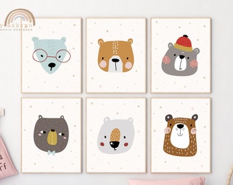 May include: Six framed art prints featuring illustrated bear faces in various colors, including blue, brown, and gray. Each bear has a unique expression and is set against a cream background with small star accents. The prints are displayed on a white wall.