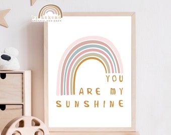 May include: A framed print featuring a pastel rainbow design with the words "YOU ARE MY SUNSHINE" in a playful font. The artwork is in a light wooden frame, suitable for nursery or children's room decor.