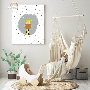 May include: A nursery scene featuring a white and wood-toned doll carriage, a hanging chair, and a framed print. The print displays a cartoon giraffe with a gray background and black polka dots. The text "by askcmn graphic designer" is in the upper left corner.