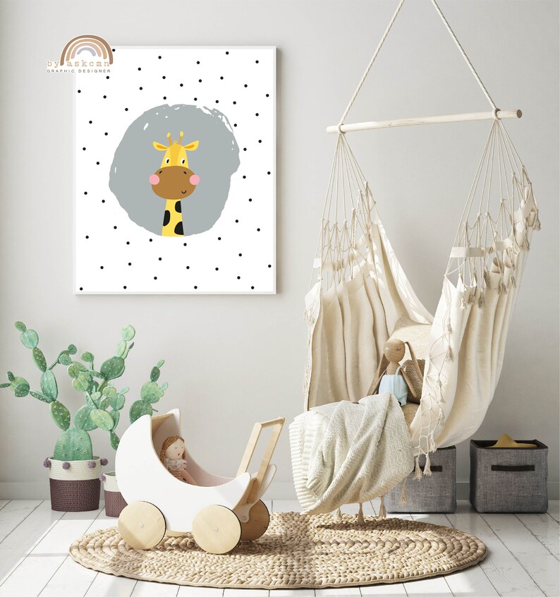 May include: A nursery scene featuring a white and wood-toned doll carriage, a hanging chair, and a framed print. The print displays a cartoon giraffe with a gray background and black polka dots. The text "by askcmn graphic designer" is in the upper left corner.