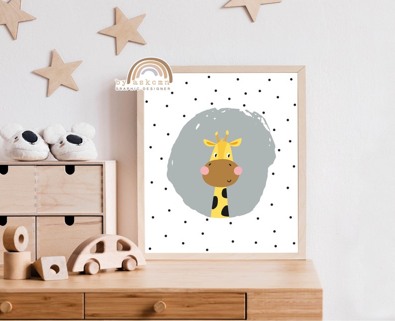 May include: A framed print featuring a cartoon giraffe with a yellow body, brown snout, and pink cheeks. The giraffe is set against a gray circle with black polka dots on a white background. The text "by askcmn graphic designer" is in the top left corner.