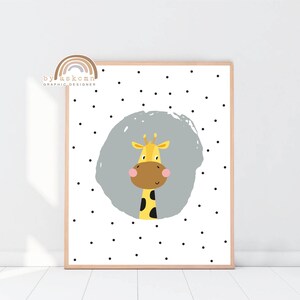 May include: A framed art print featuring a cartoon giraffe with a yellow body, brown snout, and a gray background. The giraffe is centered on a white background with black polka dots. The text "by askcmn graphic designer" is in the upper left corner.